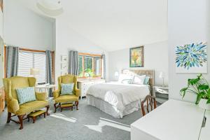 Un dormitorio con una cama y dos sillas. en Bayview Bed and Breakfast, en Mill Bay