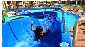 a young girl is in a swimming pool at بلوباى آسيا العين السخنه in Ain Sokhna +4 photos