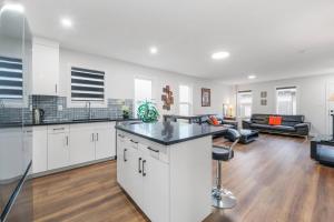 an open kitchen and living room with white cabinets at Spacious Home • 3BR • Close to Whyte and Downtown in Edmonton