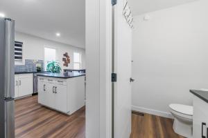 a white kitchen with a sink and a toilet at Spacious Home • 3BR • Close to Whyte and Downtown in Edmonton +19 photos