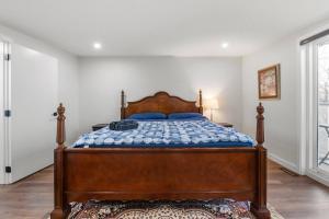a bedroom with a wooden bed with blue pillows at Spacious Home • 3BR • Close to Whyte and Downtown in Edmonton