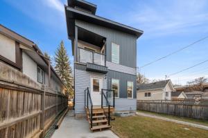 a gray house with a wooden fence at Spacious Home • 3BR • Close to Whyte and Downtown in Edmonton