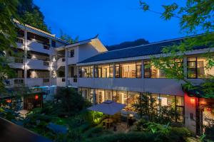 Una vista exterior de un hotel por la noche. en Serene Peaks Courtyard-Free pick-up-Free Laundry, en Fenghuang