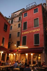 un grupo de personas sentadas en mesas frente a un edificio en Albergo al Tiepolo, en Venecia