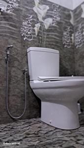 Un inodoro blanco en un baño con ducha. en Ocean's Whisper, en Tangalle