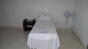 a hospital room with a bed and a fan at Pousada Flor Dos Ipês in Trindade