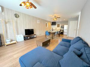 un soggiorno con un divano blu e un tavolo di OKINAWA POOLWILLA ONNA 4A - Vacation STAY 06955v a Baba
