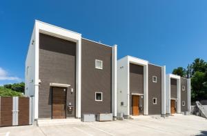 una fila di edifici bianchi e marroni in un parcheggio di OKINAWA POOLWILLA ONNA 4A - Vacation STAY 06955v a Baba