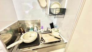 ein kleines Badezimmer mit Waschbecken und zwei Spiegeln in der Unterkunft Good One Awaji Accessia 301 in Osaka