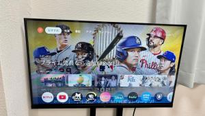 ein Fernseher mit einem Bild von Baseballspielern darauf in der Unterkunft Good One Awaji Accessia 301 in Osaka