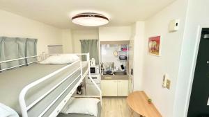ein kleines Schlafzimmer mit Etagenbett und eine Küche in der Unterkunft Good One Awaji Accessia 301 in Osaka