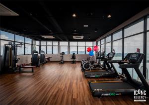 a gym with treadmills and ellipticals in a room with windows at Iconic Regency Service Residences, managed by Iconic Hotel in Bayan Lepas +8 photos