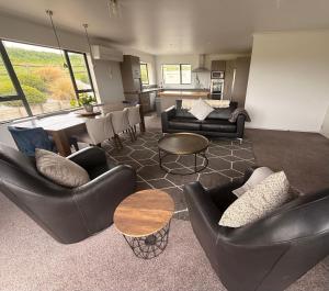 a living room with couches and a dining room at Mountain Pure Lodge in Gore