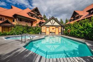 a house with a swimming pool in front of a house at Private Hot Tub | Pool | AC | Free Parking in Whistler
