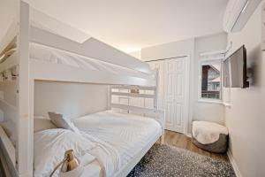 a white bedroom with a bunk bed and a window at Private Hot Tub | Pool | AC | Free Parking in Whistler +14 photos