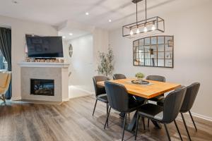 a dining room with a table and chairs and a fireplace at Private Hot Tub | Pool | AC | Free Parking in Whistler