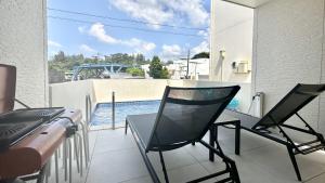 a patio with two chairs and a television on a balcony at Grandioso Onna 7-D - Vacation STAY 17402v in Atsutabaru