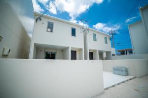 a white house behind a white wall at Grandioso Onna 7-D - Vacation STAY 17402v in Atsutabaru