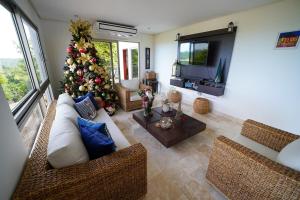 Casa Juliana vista al mar piscina y jacuzzi في Tubará: غرفة معيشة فيها شجرة عيد الميلاد وتلفزيون
