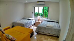 Casa Juliana vista al mar piscina y jacuzzi في Tubará: غرفة نوم بها سريرين وأريكة ونافذة +33 صورة