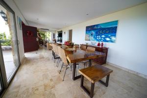 Casa Juliana vista al mar piscina y jacuzzi في Tubará: غرفة طعام مع طاولات وكراسي ولوحة فنية