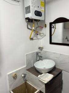 un baño con lavabo y espejo en Casa Linda, en Armenia
