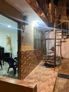 Habitación con pared de ladrillo y escalera. en Casa Linda, en Armenia 1 foto más