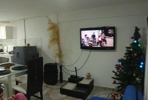 Una sala de estar con un árbol de Navidad y un televisor. en Casa Linda, en Armenia