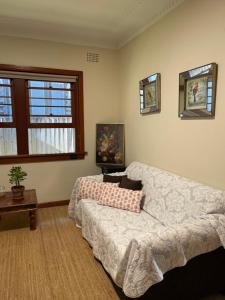 a living room with a couch and a window at SUNNY STUDY ROOM ATTACHED IN SPACIOUS PRIATE ROOM Eastwood in Sydney