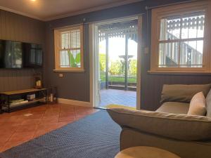 a living room with a couch and a sliding glass door at Windsor Retreat City Views - Garden Suite in Brisbane