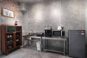 a kitchen with a counter with a microwave and a refrigerator at LEJU 79 樂居 A Heritage Getaway in the Heart of Melaka in Malacca +14 photos