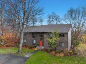 a house with a red door in a yard at Torch Lake Vista A Ga Ming Golf Retreat 741 Unit 9A in Creswell