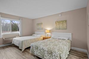 a bedroom with two beds and a window at Torch Lake Vista A Ga Ming Golf Retreat 741 Unit 9A in Creswell +12 photos