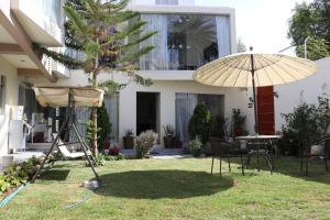 a patio with an umbrella and a table and chairs at Hotel Florez Boutique in Arequipa