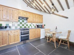 a kitchen with wooden cabinets and a table with chairs at 1 Bed in Eskdale SZ471 in Beckfoot +22 photos
