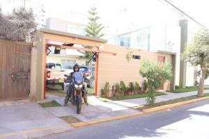 a person on a motorcycle parked in front of a house at Hotel Florez Boutique in Arequipa