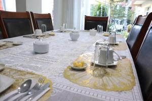 a dining room table with a table set with utensils at Hotel Florez Boutique in Arequipa
