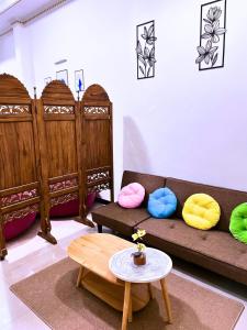 - un salon avec un canapé, des oreillers et une table dans l'établissement SIJI Homestay Purwokerto, à Purwokerto