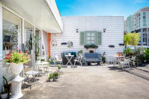 a patio with chairs and tables and a house at Take a Rest Donmueang in Ban Don Muang