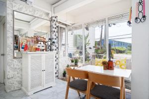 a room with a table and chairs and a window at Take a Rest Donmueang in Ban Don Muang