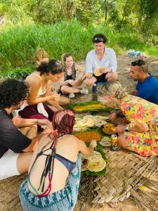 a group of people sitting around a picnic table at Dub & Drum hostel in Sigiriya