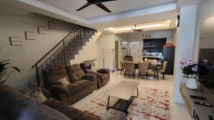 a living room with a couch and a table at Fawa Homestay Jasin in Jasin +3 photos