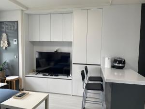 アンサンにあるRiver & Hill view roomのリビングルーム(白いキャビネット付)、キッチンが備わります。