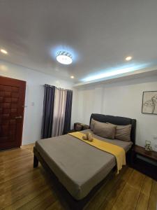 a bedroom with a bed with a yellow blanket on it at Jex Poolpoint Villa in El Nido