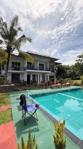 a villa with a swimming pool in front of a house at WILSON VILLA in Hikkaduwa