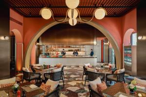 a restaurant with tables and chairs and a kitchen at Hotel Indigo Wuxi Qingming Bridge in Wuxi