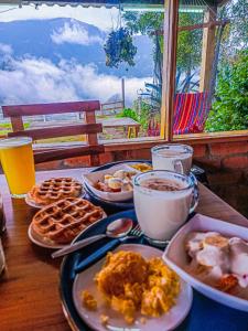 a table topped with plates of breakfast food and drinks at Sigchos Lodge in Sigchos