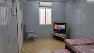 a living room with a tv and a window at Warisan Nyonya Cabin Homestay Alor Gajah in Kampong Jelatang