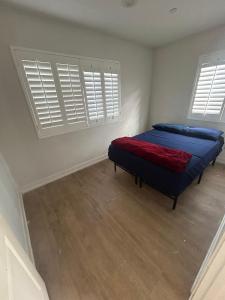 1 Schlafzimmer mit einem Bett mit blauer Bettwäsche und 2 Fenstern in der Unterkunft Santa Ana Vibes in Santa Ana + 1 Foto