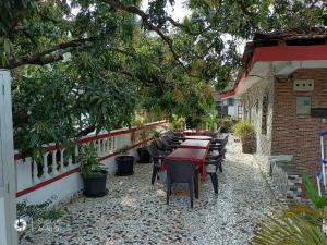AguadaAlexmarie Guest house 5 min to candolim Beach的有桌椅和树木的露台